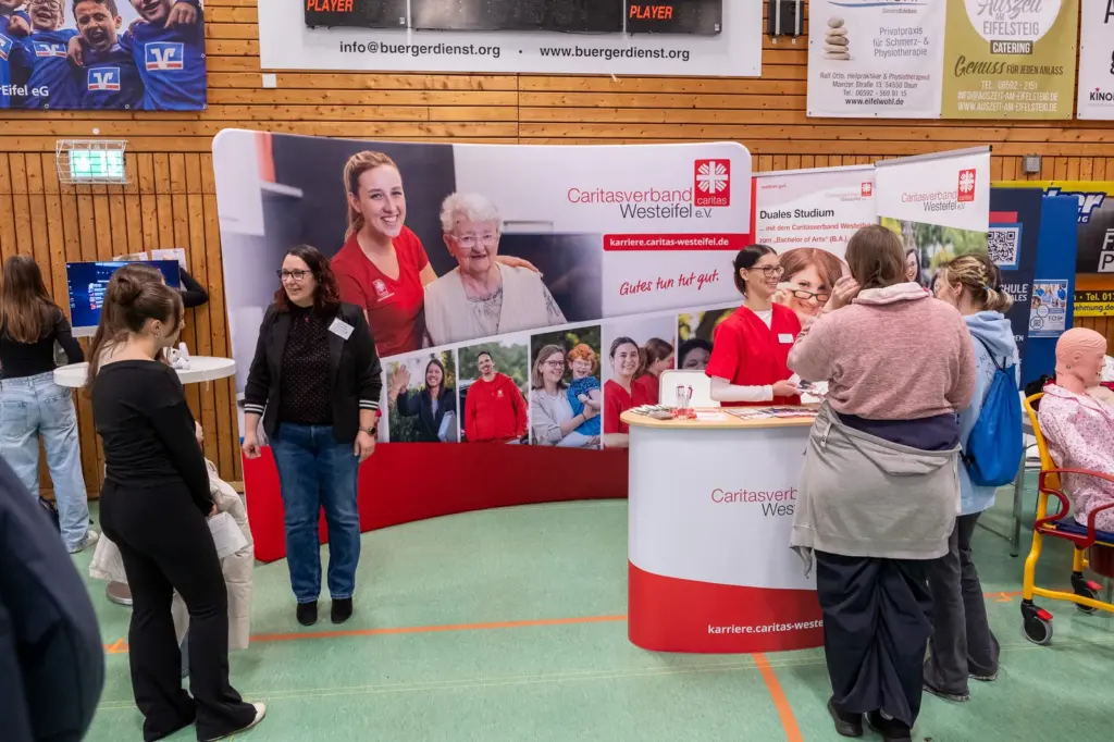 Besucherinnen und Besucher im Gespräch an einem Messestand